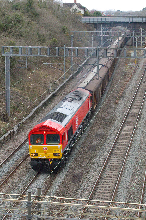 66088, 11.33 Dollands Moor-DIRFT (6M45, 4E), Hyde Road bridge 
 My return walk home happened to coincide with the passing of the daily bottled water train. 66088 leads the 6M45 11.33 Dollands Moor to Daventry through Roade passing Hyde Road bridge. The former EWS Class 66 has only been photographed once before, see. https://www.ontheupfast.com/p/21936chg/24848715004/x66088-17-36-southampton-eastern and looks as though it is one that has recently been repainted and branded into its DB colours. 
 Keywords: 66088 11.33 Dollands Moor-DIRFT 6M45 Hyde Road bridge DB Water train