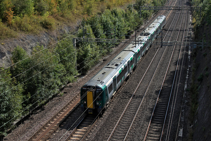 350369, LN 11.54 London Euston-Northampton (2N13, RT), Roade Cutting 
 The rate at which London Northwestern are re-painting their class 350s is very slow. Long may that continue as the drab front end treatment that they are giving them is absolutely awful! I cannot believe that some graphic designer has been allowed to create this and even more so that it has been approved by the company! Here, 350369 has received the treatment and passes through Roade Cutting forming the 11.54 Euston to Northampton. 
 Keywords: 350369 2N13 Roade Cutting