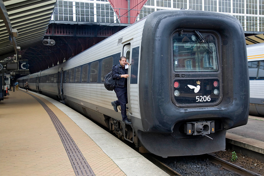 5206, 15.37 Copenhagen Central-Nykbing Falster, Copenhagen Central station 
 The driver of DSB IC3 number 5206 'Kristine Svendsdatter' climbs aboard his train at Copenhagen Central station. I travelled on this train, the 15.37 to Nykbing Falster as far as Roskilde. I consciously decided to travel on this diesel train rather than one of the locomotive-hauled services to compare this unit with the latter. Despite its unfortunate looks, the unit was comfortable and roomy with some invertible noise from the underslung six-cylinder Deutz engines. This particular unit holds a speed record at one hundred and twenty-eight miles per hour between rup and Middelfart in October 1991; for such a slab fronted design this seems an impressive feat! 
 Keywords: 5206 15.37 Copenhagen Central-Nykbing Falster Copenhagen Central station Kristine Svendsdatter DSB IC3