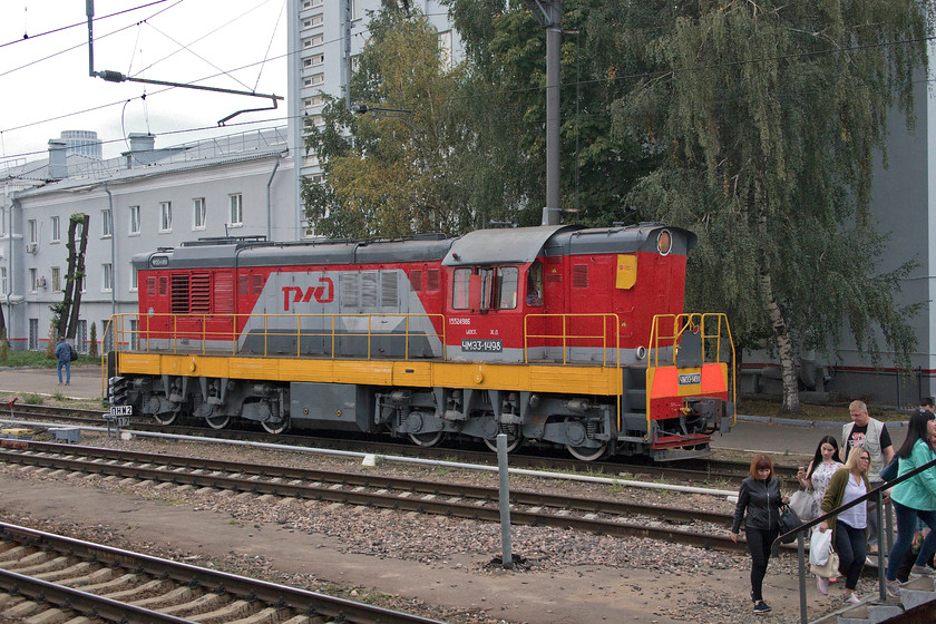 CMZ3-1498, station pilot, Moscow Belorussky station 
 Shunter, CMZ3-1498 takes a pause from it station pilot duties to allow passengers to cross the running lines to access the southern end of Moscow Belorussky station; could you imagine this at Paddington or Victoria? Whilst the tracks on Russian railways were extensively fenced there were many official and unofficial crossing points for pedestrians who cross, as here, with impunity. In addition, there was very little graffiti along the sides of the tracks, something that is at absolute epidemic proportions in the UK with every piece of trackside equipment or wall daubed with ghastly paint. 
 Keywords: CMZ3-1498 station pilot Moscow Belorussky station