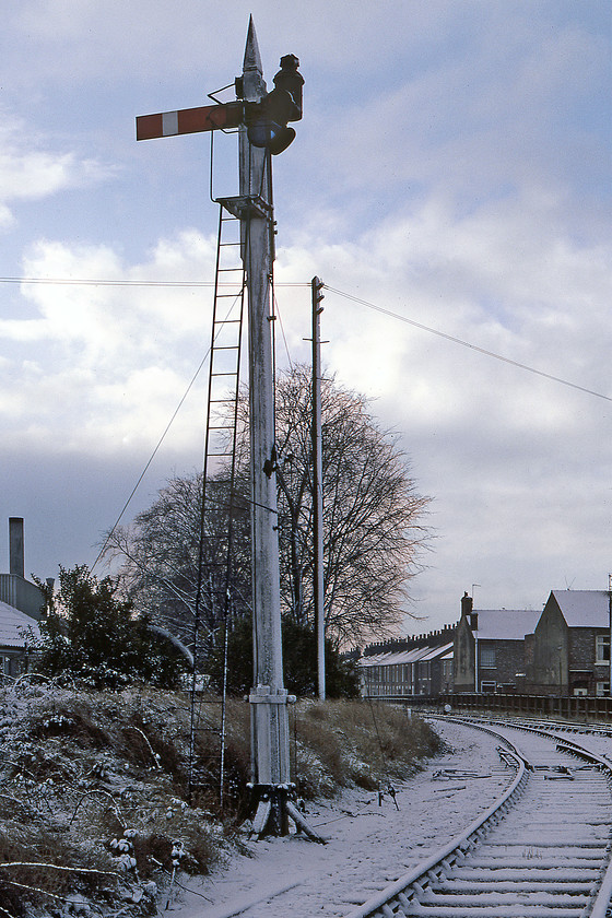 NER wooden semaphore, Burton Lane Junction, York SE602534 
 A former NER wooden semaphore post and arm are seen in the early morning light at Burton Lane Junction to the north of York's city centre. In this view, looking south-west, the York to Scarborough line can just be seen passing adjacent to the fence and the houses along Filey Terrace. The signal protects the short and, by this stage, freight-only line into the Layerthorpe industrial area. This short section of track led directly to the York (Layerthorpe) railway station, the northern terminus of the former Derwent Valley Light Railway (DVLR) that went all the way to Selby in much earlier times. The tracks here at Burton Lane Junction saw very little use by this time in 1980 and were eventually lifted in 1992. The route through York can now be enjoyed by foot or bike as the York Orbital. 
 Keywords: NER wooden semaphore Burton Lane Junction York SE602534