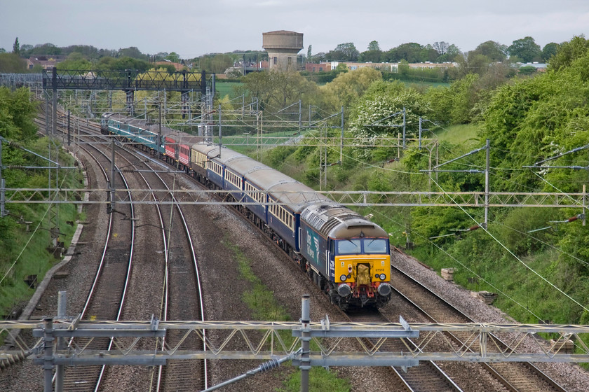 57310 & 37419, 12.44 London Euston-Crewe (1Z46), Victoria bridge 
 Former Virgin Thunderbird, 57310 'Pride of Cumbria' brings up the rear of the 1Z46 12.44 Euston to Crewe returning railtour stock. This was not running as an ecs working as passengers could pay to make this one-way trip with profits going to charity. Unfortunately, they would have been disappointed with the timings as it is runnin one hundred and twenty minutes late as it passes Roade in Northamptonshire. 37419 'Carl Haviland' is power the train at the front. Notice that the stock, that was used on the previous day's The Four Triangles railtour, is composed of four different types making for a colourful composition! 
 Keywords: 57310 37419 12.44 London Euston-Crewe 1Z46 Victoria bridge