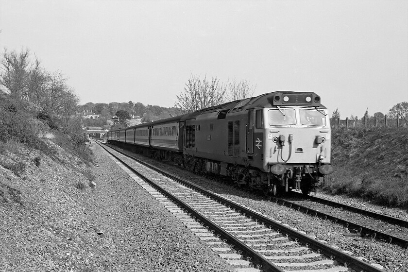 Class 50, unidentified down diverted working, Bradford-on-Avon no. 2 crossing, ST821605 
 Taken from the wrong side of the line for the sun and unidentified Class 50 accelerates away from Bradford-on-Avon with a service for the West Country. In this view, taken from one of two foot crossings to the west of the town, the station and its footbridge can be seen in the background along with the short tunnel beyond it. Notice also that the train is travelling on ancient bullhead jointed track on timber sleepers whilst the line nearest the camera has been recently renewed with continuously welded track on concrete sleepers. 
 Keywords: Class 50 down diverted working Bradford-on-Avon no. 2 crossing ST821605