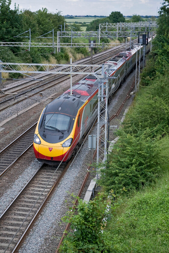 390124, VT 17.37 London Euston-Manchester Piccadilly (1H47), Victoria bridge 
 With it being early July I would have hoped for slightly better weather but I had to make do with this rather overcast evening. 390124 heads north at Victoria bridge just south of Roade working the 17.37 Euston to Manchester Pendolino service. 
 Keywords: 390124 17.37 London Euston-Manchester Piccadilly 1H47 Victoria bridge Virgin Pendolino