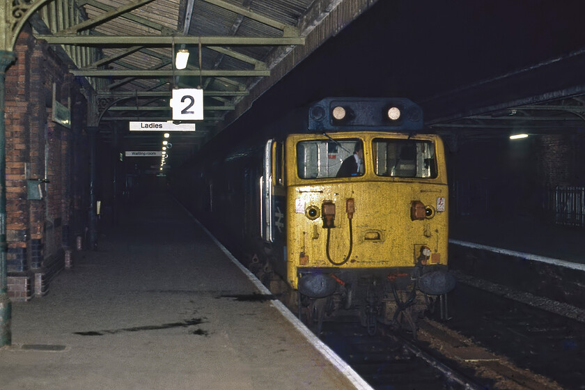 50025, 19.14 Barnstable-Basingstoke (2O96), Salisbury station 
 Breaking the rules by using my flashgun, 50025 'Invincible' is seen standing at Salisbury station. The unrefurbished Class 50 has just arrived at the station leading the 19.14 Barnstable to London Waterloo 2O96 service that it will have led from Exeter St. David's. Invincible was to enter Doncaster Works for its much-needed refurbishment at the start of February 1982 with it going on until withdrawal in August 1989 following a derailment whilst travelling at speed past West Ealing. The derailment was caused by vandals placing an object on the tracks, see.... https://www.youtube.com/watch?v=wG9psMfmE2U 
 Keywords: 50025 19.14 Barnstable-Basingstoke 2O96 Salisbury station Invincible