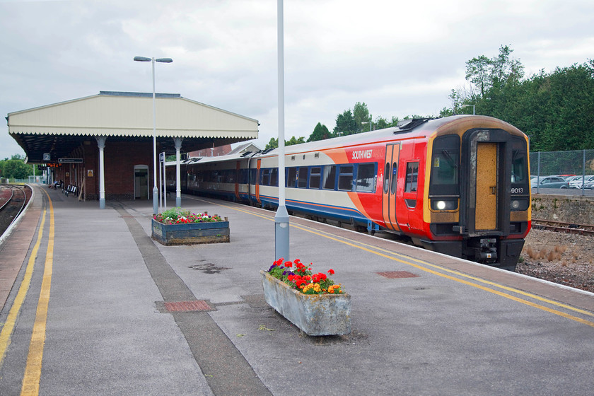 159013, SW 15.25 Exeter St. Davids-London Waterloo (1L60, 2L), Yeovil Junction station 
 Yeovil Junction station is a strangely remote spot some distance south of the town of Yeovil. All that remains of a once quite large station one central structure with a platform on either side. Here, 159013 waits at platform one with the 15.25 Exeter St. David's to London Waterloo. The huge car park that had recently been extended was packed with commuter's cars. There are various places that they could be working in none of which have a particularly fast journey, be they Salisbury, Bristol, Exeter or even London. 
 Keywords: 159013 1L60 Yeovil Junction station