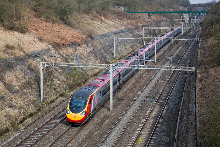 Class 390, VT 08.05 Manchester Piccadilly-London Euston, Roade cutting 
 The 08.05 Manchester to Euston Virgin service passes through a sunny Roade cutting worked by an unidentified Pendolino. This Class 390 is one of the original nine-car sets that have been in operation for ten years now; where has that time gone? 
 Keywords: Class 390 08.05 Manchester Piccadilly-London Euston Roade cutting Virgin Pendolino