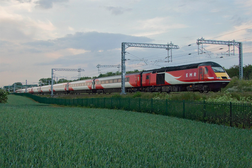 43316 & 43320, 19.04 London St. Pancras-Leeds (1D66, 3E), Irchester SP927667 
 I was keen when preparing to photograph the 19.04 St. Pancras to Leeds, knowing it was an HST, that I wanted to expose for the quite dramatic sky above the train. So it was somewhat of a compromise to ensure that the sky was a little overexposed and the foreground a little under to ensure that I was able to bring them back again in Photoshop dealing with the two parts of the photograph as separate layers. The photograph has turned out fairly well given the awful lighting conditions showing an ex LNER HST set with 43316 leading and 43320 on the rear. Having spent their working lives thrashing up and down the ECML at one hundred and twenty-five miles per hour, and often above, see....... https://www.ontheupfast.com/p/21936chg/28284142004/board-43295-13-30-edinburgh-waverley they are now having an easier time of it in their twilight months limited to one hundred and ten. 
 Keywords: 43316 43320 19.04 London St. Pancras-Leeds 1D66 Irchester SP927667 EMR East Midlands Railway Virgin Wast Coast LNER