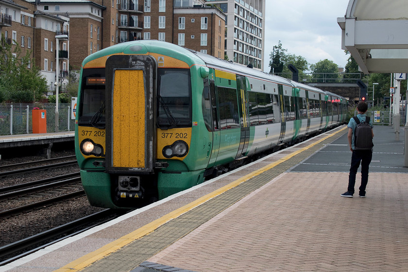 377202, SN 12.10 East Croydon-Milton Keynes Central (2M33, 3L), Kensington Olympia station 
 Our train back to Milton Keynes arrives at Kensington Olympia station. We travelled on the 12.10 Southern service that originated from East Croydon formed by 377202. Notice the young lad on the platform who was also photographing the train on his digital SLR. It's warming to see the young still taking an interest in the railways and that it's not just us old fossils out in all weathers taking photographs! 
 Keywords: 377202 12.10 East Croydon-Milton Keynes Central 2M33 Kensington Olympia station