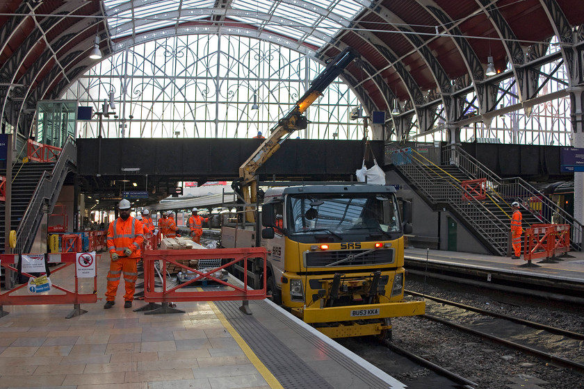 Electrification work, London Paddington station 
 An RRV (road rail vehicle) swings a bag of materials into place for the workers undertaking works a Paddington. The footbridge was being raised and the track lowered slightly in order to create the appropriate space to accommodate the 25Kv wiring on platforms one and two. I am not sure that the bearded member of the team with the dark glasses was too keen on having his picture taken! 
 Keywords: Electrification work London Paddington station