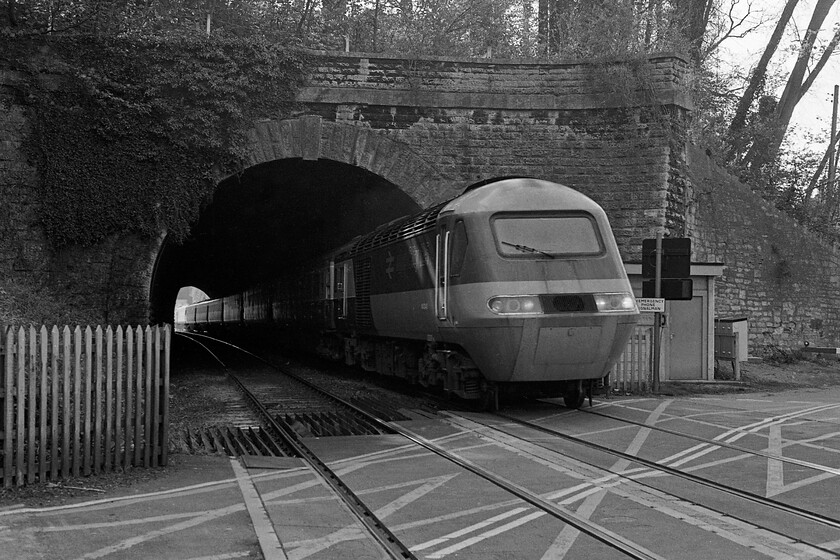 Class 43, unidentified up diverted working, Bradford-on-Avon level crossing 
 An unidentified HST passes through Bradford-on-Avon tunnel taken from Greenland Mill AHBC. The HST was an up working heading for Paddington diverted from its usual route along the GWML. It was always interesting standing at this location waiting for trains as when travelling from this direction they could be seen well in advance through the tunnel before the sirens rang and the barriers dropped but when coming from the other direction (from Bradford Junction) you got no advanced warning with the piercing 'nee-noor' from the Piezo sounder often catching one unawares! 
 Keywords: Class 43 up diverted working Bradford-on-Avon level crossing HST