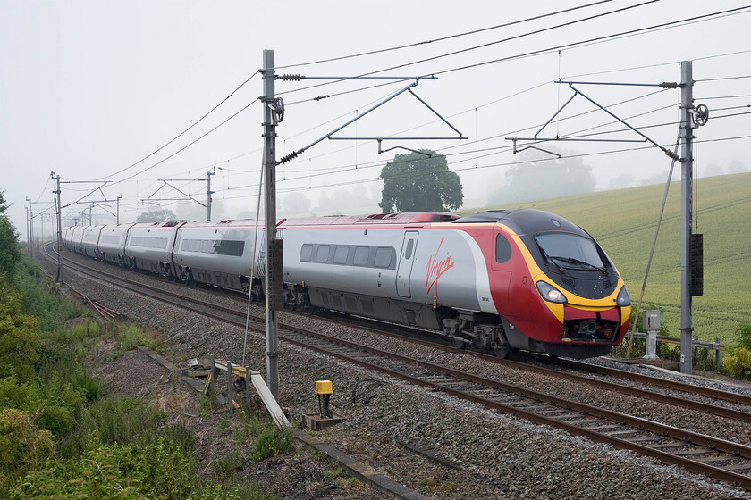 390045, VT 07.20 London Euston-Manchester Piccadilly, Blisworth SP735539 
 In an unusually foggy June morning 390045 works the 07.20 Euston to Manchester Piccadilly Virgin Trains service. The Pendolino is seen passing Blisworth on the Weedon loop that avoids Northampton. 
 Keywords: 390045 07.20 London Euston-Manchester Piccadilly, Blisworth SP735539 Virgin Trains Pendolino