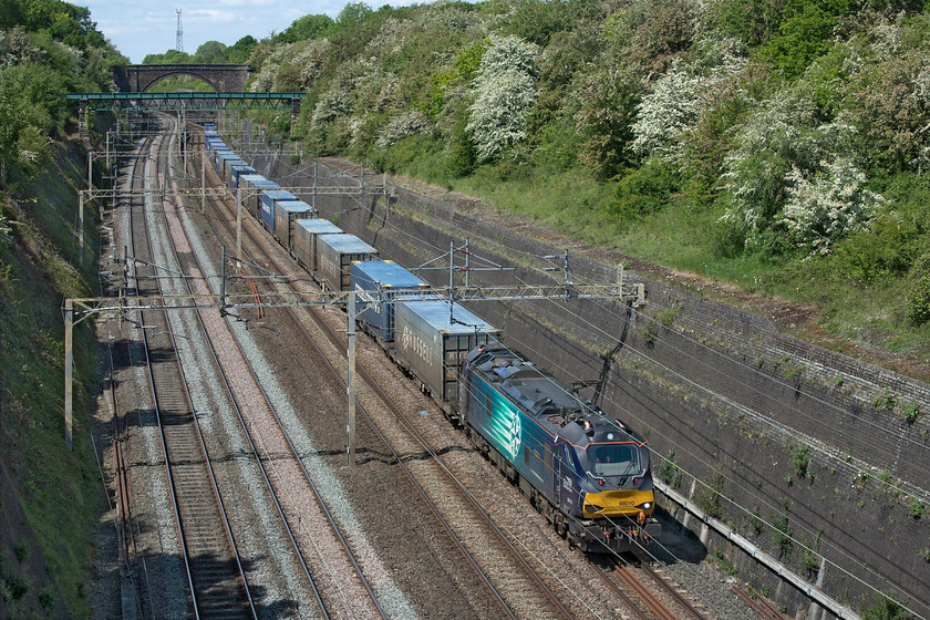 88010, 14.32 DIRFT-Mossend Down yard (4Z45, 3E), Roade cutting 
 Class 88s are pretty unusual south of Daventry on the WCML, especially when working a train to Scotland! 88010 'Auora' races through Roade cutting heading the 14.32 DIRFT to Mossend that will change direction after taking the north London line to head north on the ECML. This train will travel five hundred and ten miles on its journey to Mossend. It was quite noticeable how much faster the Class 88 was passing through Roade cutting than the more normal Class 66s that do tend to labour on the steady rising gradient south of Northampton. 
 Keywords: 88010 14.32 DIRFT-Mossend Down yard 4Z45 Roade cutting Auora DRS Direct Rail services