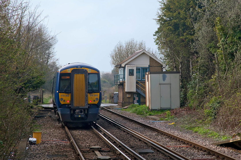 375302, SE 14.10 London Charing Cross-Ramsgate (2R43, RT), Sandwich level crossing 
 Under some pleasant late afternoon blue sky, 375302 leaves Sandwich station forming the 14.10 London Charing Cross to Ramsgate via Ashford and Dover. The train is just crossing the level crossing with New Street and passing the former signal, now crossing box. 
 Keywords: 375302 2R43 Sandwich level crossing