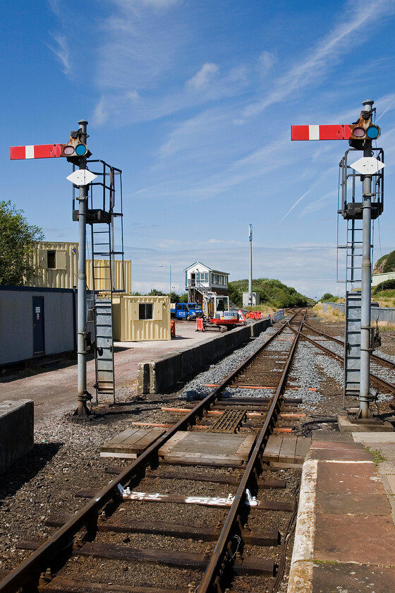 Down starters, Bransty signal box (LNW, 1899), Whitehaven station 
 Taken from the platform end of Whitehaven station the up starter signals, BY53 and BY55, dominate the scene. These semaphores are controlled by Bransty signal box which is seen in the background. The line in the foreground leads into a short bay platform that sees little use. 
 Keywords: Down starters Bransty signal box LNWR 1889 Whitehaven station