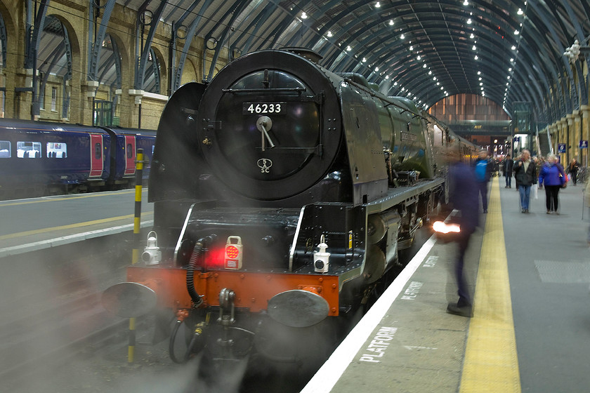 46233, return leg of The Lindum Fayre, 17.41 Lincoln-London King's Cross (1Z48), London King's Cross station 
 46233 'Duchess of Sutherland' rests on the blocks at London King's Cross as a member of the cab crew changes the headlight with a tail light. The 1938 built LMS Coronation Class has just brought the 1Z48 Lindum Fayre charter back from Lincoln where its passengers have enjoyed a pre-Christmas day out sampling the extensive seasonal market. The Railway Touring Company will be pleased that the day has gone without a hitch with both the outward and return workings running exactly to time with no hitches. 
 Keywords: 46233 The Lindum Fayre, 17.41 Lincoln-London King's Cross 1Z48 London King's Cross station Railway Touring Company