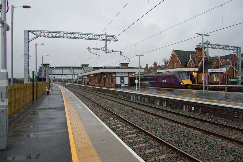 222009, EM 11.12 Nottingham-London St. Pancras (1B36, 2L), Wellingborough station 
 A wide angled photograph showing the completely new view from the north end of Wellingborough's rebuilt and reinstated platform four. Whilst facilities on the other platforms are generous those on this new one are a little limited with just some benches and a small bus shelter style waiting room adjacent to the footbridge. 222009 is about to depart south with the 11.12 Nottingham to St. Pancras service in torrential rain that prevailed throughout the day. 
 Keywords: 222009 11.12 Nottingham-London St. Pancras 1B36 Wellingborough station EMR East Midlands Railway.