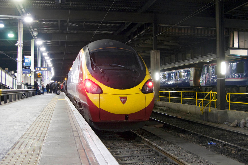 390043, VT 20.07 London Euston-Liverpool Lime Street (1F27) & 90019, SR 19.34 Wembley-London Euston ECS (5S95), London Euston station 
 A Virgin Trains Pendolino waits at Euston to leave with the 20.07 to Liverpool Lime Street. To the right of 390043 is ScotRail branded 90019 that has brought the 5S95 ECS sleeper stock in from Wembley. I have adopted this low camera angle as I was using my newly bought mini tripod that lives in a small pocket of the camera pouch. This enabled me to use a long shutter speed thus meaning I could reduce the ISO to minimise digital noise. 
 Keywords: 390043 20.07 London Euston-Liverpool Lime Street 1F27 90019 19.34 Wembley-London Euston ECS 5S95 London Euston station