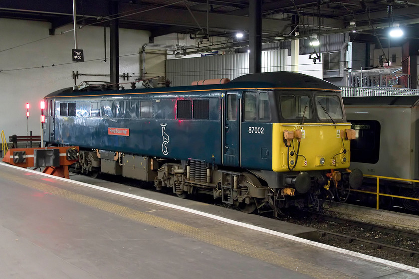 87002, stabled, London Euston station 
 87002 'Royal Sovereign' sits on the blocks at London Euston having brought in the empty coaching stock for the 'Highland' Caledonian Sleeper earlier in the evening from Wembley. The train had already left by the time we arrived back at Euston and we left just too early for the 'Lowland' so I missed both of them! Time is about to be called on this June 1973 AC electric as its work with CS will come to end when the 'Highland' sleeper goes over to the Mk. IV stock by the end of next month as this loco. is not compatible with the new stock. 
 Keywords: 87002 stabled London Euston station