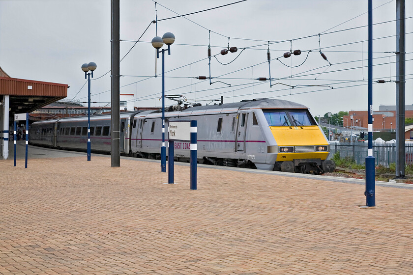 91105, GR 14.30 London King's Cross-Newcastle (1N21), York station 
 East Coast's 91105 leads the 14.30 King's Cross to Newcastle away from York station. In this view, the platform furniture still retains the colours of the much-lamented (by many but not necessarily me!) GNER with their corporate blue still much in evidence despite the TOC losing the franchise seven years ago. 
 Keywords: 91105 14.30 London King's Cross-Newcastle 1N21 York station East Coast InterCity 225