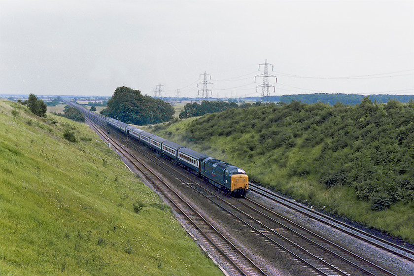 55017, 15.00 London Kings Cross-Aberdeen (1S31), Westby SK962271 
 Just look at the straightness of the ECML stretching off into the distance down Stoke Bank. The picture is taken from the lofty heights of a large bridge that spans the line about two miles from the village of Westby, a superbly quiet and open spot. By 2019, the vista has become much more enclosed due to un-managed growth on the embankments, see.... https://www.ontheupfast.com/v/photos/21936chg/26500884804/x158862-08-57-norwich-liverpool-lime This is the section of line that in July 1938 was where 4468 'Mallard' completed its record-breaking 126mph run using this initial straight drop from Stoke to build up the speed. The record speed was actually attained just north of Essendine some six miles up the line from this spot. On this day, in August 1978, there is no classic steam action so a Deltic had to suffice! 55017 'The Durham Light Infantry' races up Stoke with the 1S31 15.00 King's Cross to Aberdeen. 
 Keywords: 55017 15.00 London Kings Cross-Aberdeen 1S31 Westby SK962271