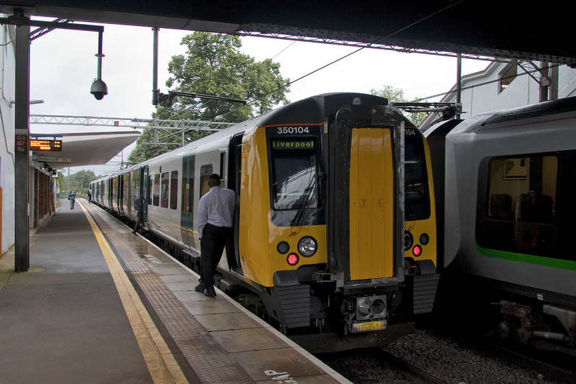 350109, LN 09.18 Birmingham International-Liverpool Lime Street (1F37, 2L), Lea Hall station 
 If this is the new, revised London Northwestern livery then it is a massive improvement on their all-over metallic green variant with just the connecting door painted yellow. The guard nonchalantly leans against 350109 as it prepares to leave Lea Hall station with the 09.18 Birmingham International to Liverpool Lime Street 1F37 service. 
 Keywords: 350109 09.18 Birmingham International-Liverpool Lime Street 1F37 Lea Hall station