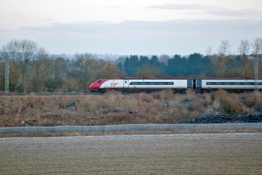 390128, VT 07.20 London Euston-Manchester Piccadilly (1H09, 2L), Bugbrooke SP673563 
 In the early morning cold light, 390128 'City of Preston' heads north around the Weedon loop near to Bugbrooke forming the 07.20 Euston to Manchester Piccadilly. There is still the remnants of yesterday's snow on the ground and it was a frosty morning following a cold night so the fields I crossed to get to this location were frozen hard. 
 Keywords: 390138 07.20 London Euston-Manchester Piccadilly 1H09 Bugbrooke SP673563