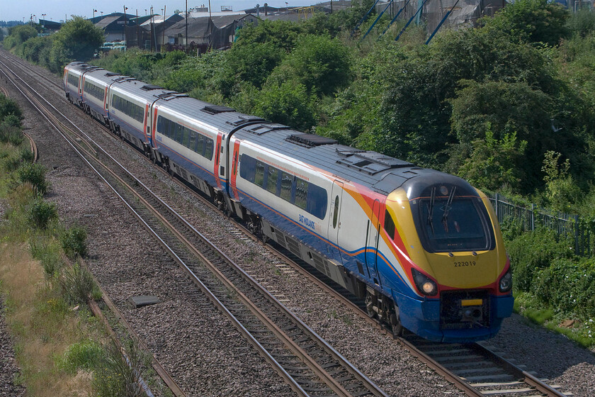 222019, EM 09.29 London St. Pancras-Nottingham (1D19), Finedon Road industrial estate SP900702 
 With Wellingborough's Finedon Road industrial estate in the background, 222019 passes with the 09.20 St. Pancras to Nottingham 1D19 service. Despite it being a hot and clear July day with a brilliant blue sky (that did cloud up a little later on during my visit) photography in these conditions can be tricky. With extremely strong sun and with it being high and overhead deep shadows are created that themselves need some fettling during processing on the computer. 
 Keywords: 222019 09.29 London St. Pancras-Nottingham 1D19 Finedon Road industrial estate SP900702 ESR East Midlands Trains Meridian