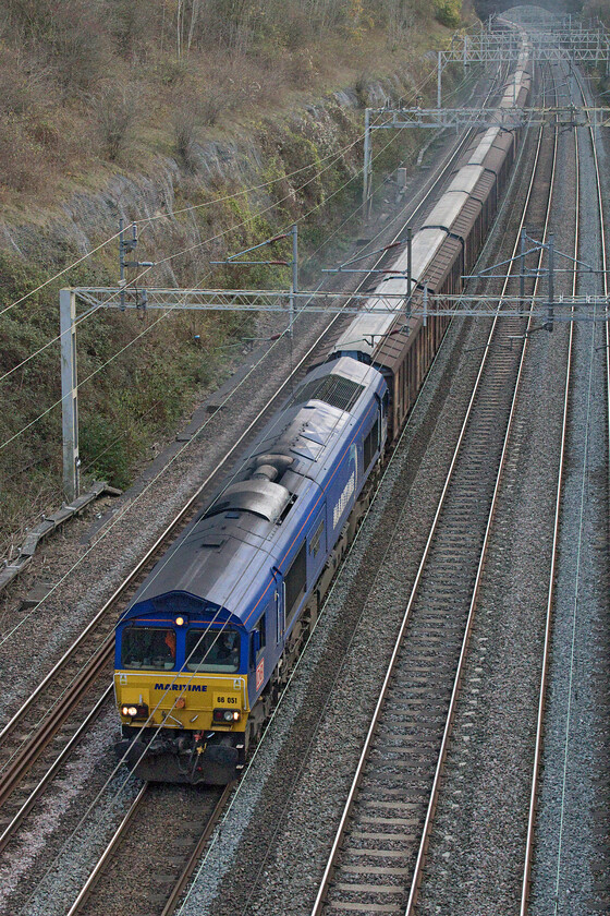 66051, 06.53 Dollands Moor-DIRFT (6M45, 4E), Roade cutting 
 A significant photographic cop (In this livery at least) in Roade cutting! 66051 'Maritime Intermodal Four' is the final one of the eight Maritime liveried (but GBRF operated) Class 66s to be captured by my lens. It is seen passing through Roade cutting leading the 6M45 06.53 Dollands Moor to Daventry (DIRFT) bottled water train. Whilst my photographic quest is over the only image that I have of 66162 'Maritime Intermodal Five' is a little disappointing, see.... https://www.ontheupfast.com/p/21936chg/30031287625/x66162-maritime-intermodal-five-66069 being taken from a distance from Toton's infamous bank so a better image is in order! 
 Keywords: 66051 06.53 Dollands Moor-DIRFT 6M45 Roade cutting Maritime Maritime Intermodal Four