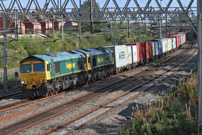 66550 & 66533, 09.46 Felixstowe North-Crewe Basford Hall (4M87, 137L), site of Roade station 
 I think that something had gone wrong earlier in its journey as the 4M87 09.46 Felixstowe to Crewe was running over two hours late here at Roade. With 66533 'Hanjin Express/Senator Express' seemingly going along for the ride tucked in behind 66550 I suspect that it had failed. The train is seen in the afternoon sunshine heavily loaded plodding along the down slow line eventually arriving at Crewe one hundred and thirty-seven minutes late. 
 Keywords: 66550 66533 09.46 Felixstowe North-Crewe Basford Hall 4M87 site of Roade station Hanjin Express / Senator Express