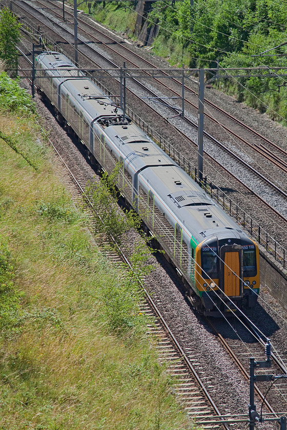 350118, LM 10.49 London Euston-Birmingham New Street (1W09), Roade Cutting 
 350118 passes the northern end of Roade Cutting with the 10.49 Euston to Birmingham New Street. You can see that the slow lines are just beginning to drop away from the fast lines. This marks the point where the two lines diverge to go via either Weedon or Northampton to join each other again at Hillmorton Junction just south of Rugby. 
 Keywords: 350118 1W09 Roade Cutting