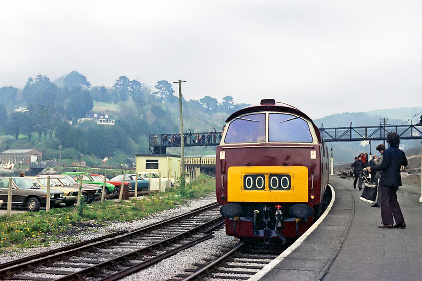 D1062, 16.00 Paignton-Kingswear, Kingswear station 
 D1062 'Western Courier' looks resplendent in its maroon livery with small yellow ends as it arrives at Kingswear station with the 16.00 from Paignton. There were significant numbers of visitors at the Western event on the Torbay and Devon Railway largely to do with the fact that the event was in collaboration with the RPPR's 'Western Ambassador Railtour' from Paddington that brought a significant number of enthusiasts. This section of the car park has some foreign imports darkening the scene! A Peugeot 604 saloon, a Simca, a lovely green Citroen Dyane and an Opel Manta. 
 Keywords: D1062 16.00 Paignton-Kingswear Kingswear station