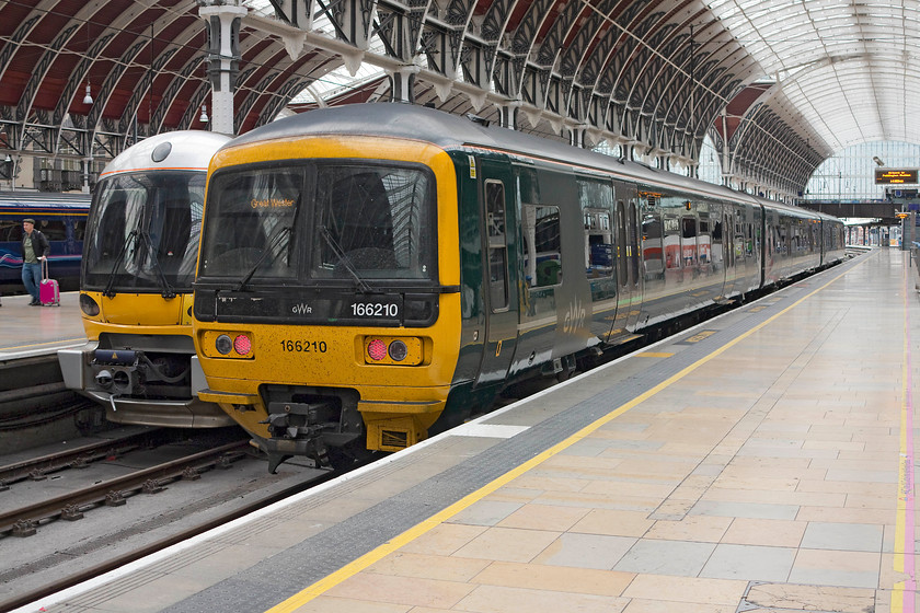 166210, GW 14.50 London Paddington-Oxford (1D30, 4L) & 332008, HX 14.55 London Paddington-Heathrow Airport T5 (1T63, 5L), London Paddington station 
 In its new drab green livery, 166210 waits to work the 14.50 to Oxford. These Turbostars are about to be cascaded to other parts of the network as the new class 387s are introduced. Next to the 166 is Heathrow Express' 332008 that will work the 14.55 to Heathrow Terminal 5. 
 Keywords: 166210 1D30 332008 1T63 London Paddington station