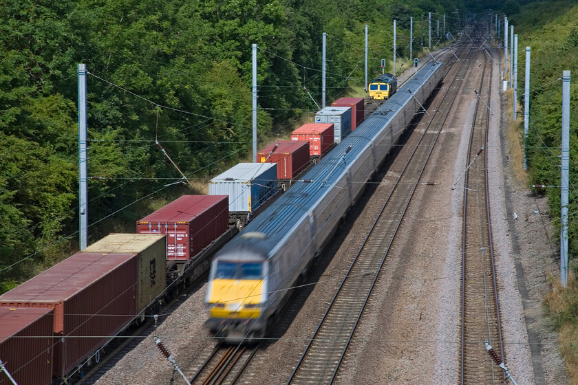 66593, 06.14 Felixstowe North-Leeds FLT (4E22) & DVT, 10.03 London King's Cross-Leeds (1D09), Westby SK96227 
 A deliberately slow shutter speed captures 66593 held at a red signal leading the 4E22 06.14 Felixstowe North to Leeds FLT whilst the 10.03 King's Cross to Leeds displays significant motion blur as it passes northwards at line speed. This scene is recorded from a tall overbridge spanning the line towards the top of Stoke Bank near Westby. 
 Keywords: 66593 06.14 Felixstowe North-Leeds FLT 4E22 DVT 10.03 London King's Cross-Leeds 1D09 Westby SK96227 East Coast DVT Freightliner