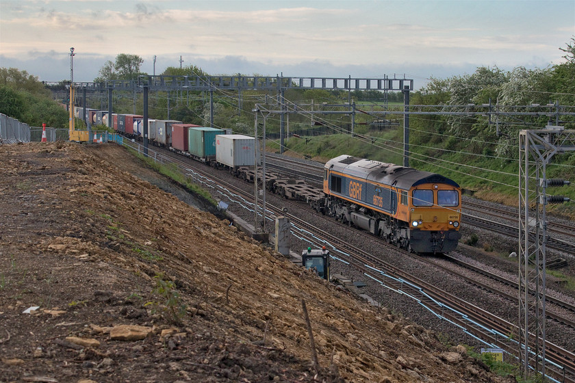 66735, 03.10 Felixstowe North-Trafford Park (4M21, 10E), Ashton Road bridge 
 66735 'Peterborough United' leads the 03.10 Felixstowe to Trafford Park 4M21 Freightliner past Ashton Roade bridge just south of the village of Roade. It is passing the worksite that has remained closed since the tragic death of a contractor at the beginning of last month. Once the enquiry is completed the site will reopen and work can continue to stabilise the collapsing embankment. 
 Keywords: 66735 03.10 Felixstowe North-Trafford Park 4M21 Ashton Road bridge Freightliner