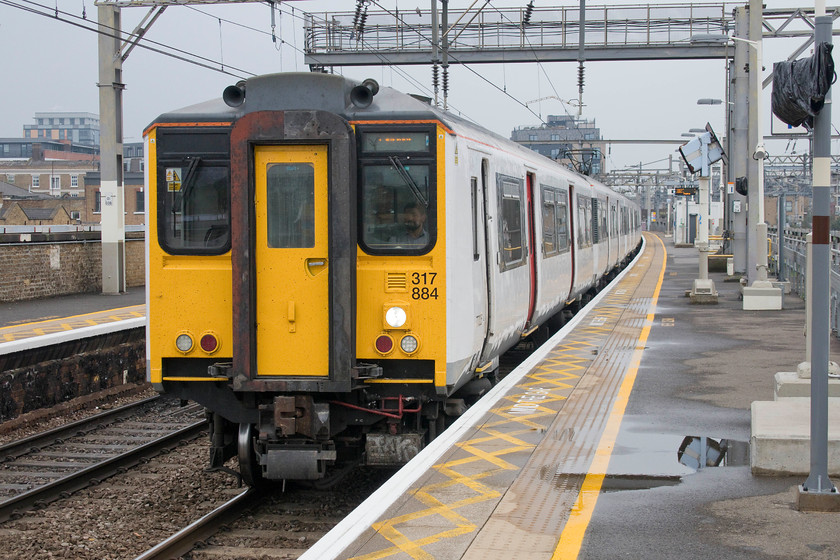 317884, LE 12.04 Cambridge-London Liverpool Street (2H29, 1L), Bethnal Green station 
 317884 passes through Bethanl Green station forming the 12.04 Cambridge to London Liverpool Street. This service is operated by Greater Anglia who will soon be withdrawing these veteran EMUs to replace them with the class 720s. I am sure that the commuters to and from Cambridge will appreciate the new units, not least their air conditioned interiors! 
 Keywords: 317884 12.04 Cambridge-London Liverpool Street 2H29 Bethnal Green station