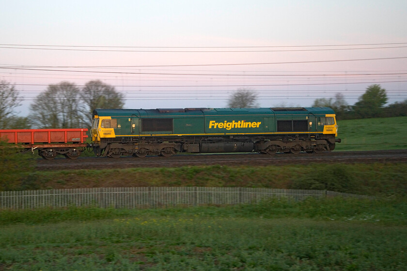 66540, 02.43 Crewe Basford Hall-Bletchley flyover (6Y52, 4L), between Roade & Ashton 
 Bringing up the rear of the 02.43 Crewe Basford Hall to Bletchley flyover infrastructure working 66540 'Ruby' just catches some very early morning light at just before 05.30. The train is composed of a rake of former BDA/BEA wagons repurposed into MXA wagons that have gained the nickname lobsters quite appropriate given their colour! 
 Keywords: 66540 02.43 Crewe Basford Hall-Bletchley flyover 6Y52 between Roade & Ashton Freightliner Ruby