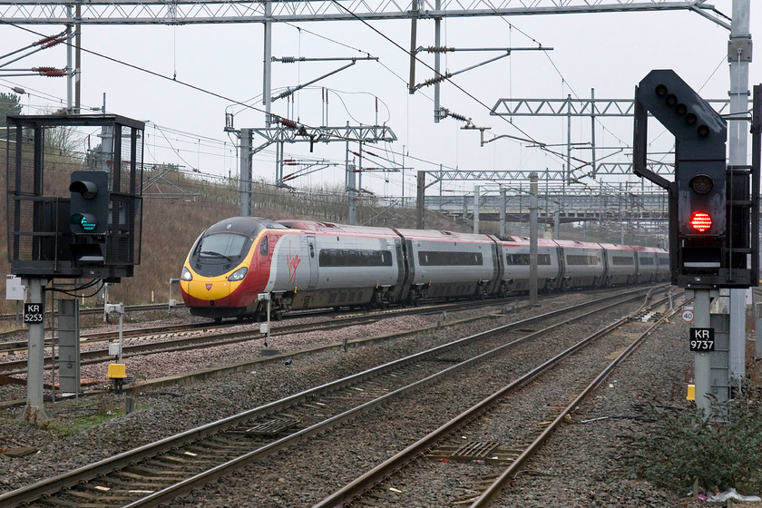 390011, VT 08.15 Manchester Piccadilly-London Euston (1A12), Milton Keynes Central station 
 390011 'City of Lichfield' slows for its stop at Milton Keynes. It is forming the 1A12 08.15 Manchester Piccadilly to London Euston. As can be seen in this image, it was a particularly dingy winter's day, one that I find utterly depressing making me yearn for the arrival of spring. 
 Keywords: 390011 08.15 Manchester Piccadilly-London Euston 1A12 Milton Keynes Central station