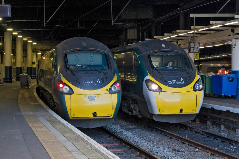 390002, VT 08.43 Liverpool Lime Street-London Euston (1A16, 6L) & 390008, 11.16 London Euston-Blackpool North (9P65, 32L), London Euston station 
 A pair of 'namers' stand side by side at London Euston! To the left, 390002 'Stephen Sutton' has recently arrived working the 1A16 08.43 from Liverpool Lime Street. To its right, 390008 'Charles Rennie Mackintosh' is a minute away from departure (according to my camera's file information) with the 11.16 to Blackpool North. Unfortunately, it may have departed on time but something went awry in the Trent Valley with a severe delay that was never recovered from with its eventual arrival thirty-two minutes late. I am curious about the off-white panel in the centre of the drawbar cover of 390002. Whilst I know that this is where the former Virgin plaques were attached the bottom of the small panel is the wrong shape and too short; can anybody advise? 
 Keywords: 390002 08.43 Liverpool Lime Street-London Euston 1A16 390008, 11.16 London Euston-Blackpool North 9P65 London Euston station Avanti West Coast Pendolino AWC Stephen Sutton Charles Rennie Mackintosh