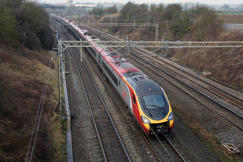 Class 390, VT 10.01 Preston-London Euston (1A10), Victoria bridge 
 An unidentified Virgin class 390 sweeps past Victoria bridge just south of Roade on the up fast forming the 10.01 SuO Preston to London Euston. Pendolinos are often seen running with their nose cone covers in the withdrawn position thus exposing their innards; I suspect that it does nothing for their aerodynamic efficiency! 
 Keywords: Class 390 10.01 Preston-London Euston 1A10 Victoria bridge