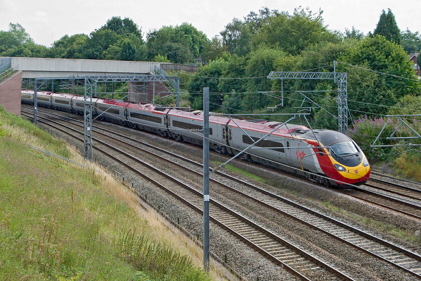 Class 390, VT 13.40 London Euston-Manchester Picaddilly (1H68), Lichfield Nether Stowe footbridge 
 An unidentified named Class 390 Pendolino passes Lichfield working the 1H68 13.40 Euston to Manchester Virgin West Coast service. The train is taken from a footbridge that permits very limited access for the photographer hence the poor positioning of the train obscured by the wiring. 
 Keywords: Class 390 13.40 London Euston-Manchester Picaddilly (1H68), Litchfield Nether Stowe footbridge Virgin Pendolino