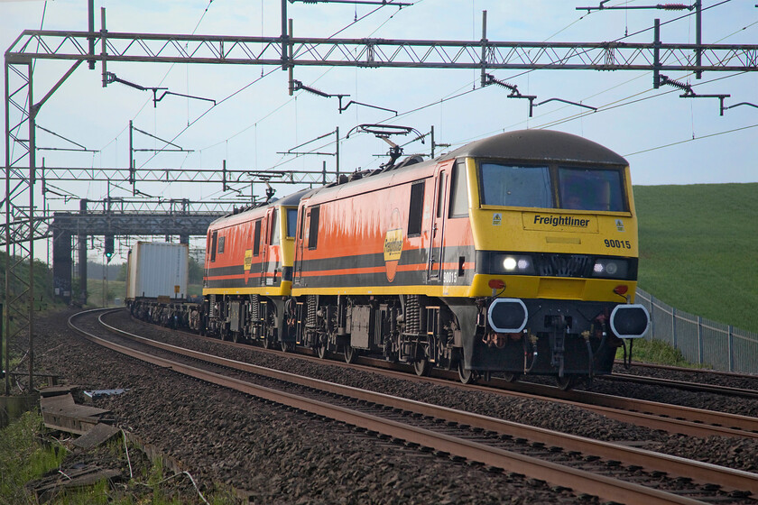 90015 & 90006, 02.57 Felixstowe North-Garston (4M45, 54E), Old Linslade 
 The low angle used to take this photograph at Old Linslade makes for an interesting composition of 90015 and 90006 'Modern Railways Magazine' as they head north leading the 4M45 02.57 Felixstowe North to Garston Freightliner. The Genesee & Wyoming livery looks very smart as applied to these former Greater Anglia Class 90s that were acquired by Freightliner during 2020. It must be remembered that these locomotives used to operate on this route back in BR and Virgin days but then they would normally have been on the adjacent fast lines and hauling Mk. III coaching stock! 
 Keywords: 90015 90006, 02.57 Felixstowe North-Garston 4M45 Old Linslade Freightliner Genesee & Wyoming Modern Railways Magazine