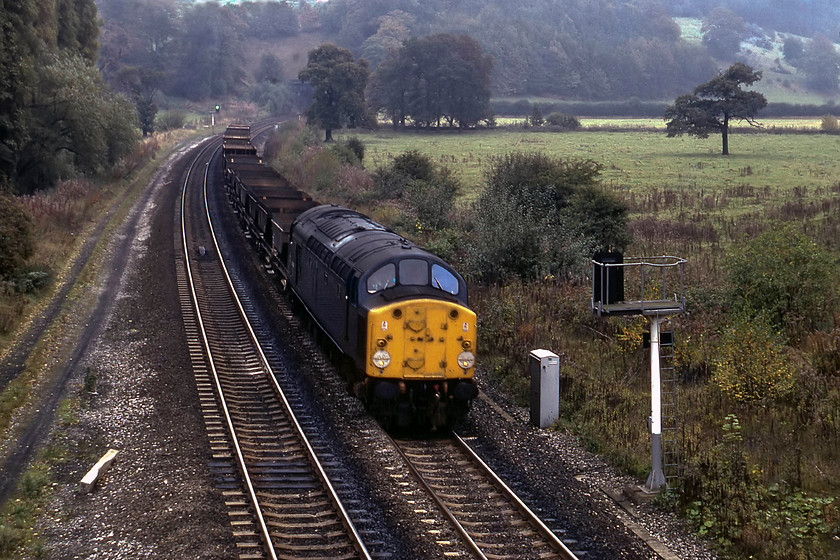 40069, up empty merry-go-round, Duffield A6 road bridge 
 As I was walking down Castle Hill in Duffield to get the train to Derby, I heard the unmistakable 'whistling' of a 40. A dash to the A6 road bridge enabled this grab shot of 40069 on an up train of empty coal hoppers. Notice the southern portal of the 855 yards long Milford Tunnel that cuts through one of a number of gritstone outcrops in this area in the background. 
 Keywords: 40069 up empty merry-go-round, Duffield A6 road bridge