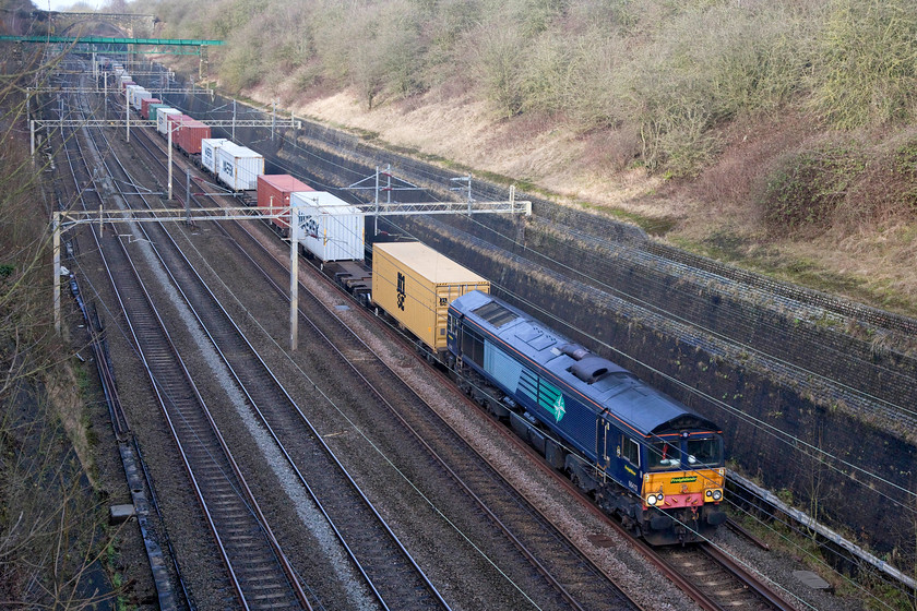 66413, 12.28 Daventy-Wembley (4L98), Roade Cutting 
 Even if it was New Year's Eve, things go on as usual as the 12.28 Daventry to Wembley 4L98 Freightliner passes through Roade Cutting. 66413 leads the train still wearing its DRS livery but with no branding as it was in use with its new operator, Freightliner, the small decals of which can be seen on the cab side. 
 Keywords: 66413 12.28 Daventy-Wembley 4L98 Roade Cutting