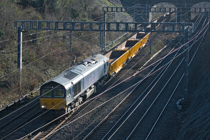 66304, 07.21 Ledburn Junction-Bescot Yard (6G61, 122L), Hyde Road bridge 
 One of five former Fastline (remember them?) Class 66s leads the 07.21 Ledburn Junction to Bescot Yard empty ballast train through Roade after being involved in New Year's work between Tring and Cheddington. Leading the late running 6G21, 66304 eventually arrived at Bescot two hours late as a result of the engineering work overrunning causing considerable disruption to all other services. 
 Keywords: 66304 07.21 Ledburn Junction-Bescot Yard 6G61 Hyde Road bridge