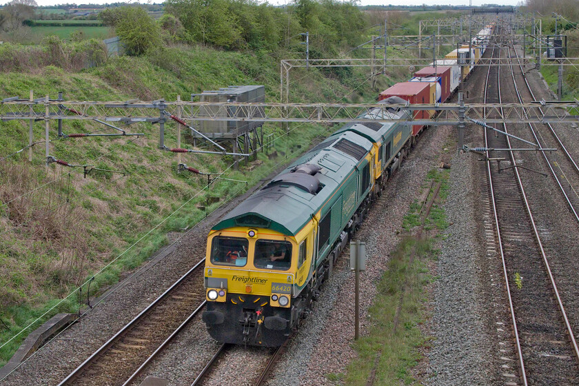 66420 & 66556, 12.57 London Gateway-Garston (4M56, 14L), Victoria bridge 
 A second example of a photograph that is not framed well due to it being surprisingly double-headed. Running very late, perhaps suggesting problems with the initial leading locomotive, the 4M56 12.57 London Gateway to Garston Freightliner passes Victoria bridge between Roade and Ashton. With 66420 now leading 66556 the train was able to pick up much of its lost time with eventual arrival at Grston just sixteen minutes late. 
 Keywords: 66420 66556, 12.57 London Gateway-Garston 4M56 Victoria bridge Freightliner