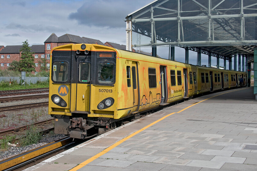 507013, ME 16.45 Chester-Chester (2C43, 4L), Chester station 
 Up for imminent replacement.

The 16.45 Chester to Chester circular Merseyrail service (via Liverpool Central) waits to leave its starting point in some pleasant and welcome afternoon sunshine. The Class 777 units that are to replace the venerable Class 507s are currently being delivered but testing, staff training and mileage accumulation seems to be taking far too long with them due to be in service by now. 
 Keywords: 507013 16.45 Chester-Chester 2C43 Chester station Merseyrail