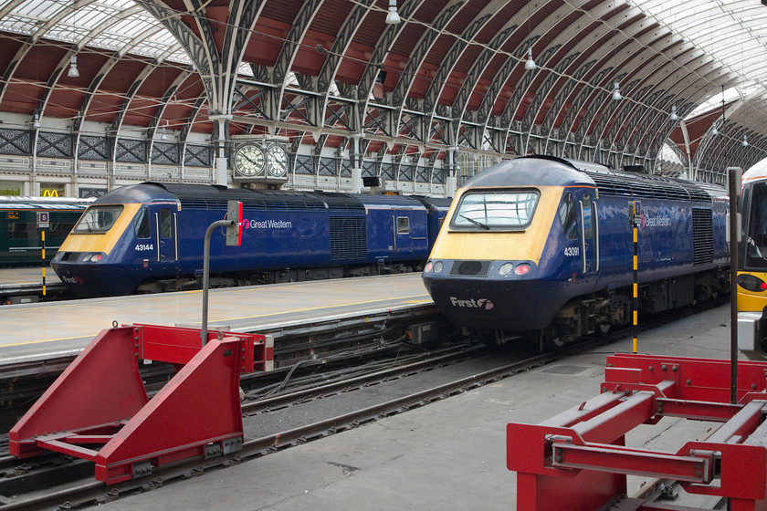 43144, GW 10.01 Pembroke Dock-London Paddington (1L62, 10L) & 43091, GW 09.57 Penzance-London Paddington (1A83, 17L), London Paddington station 
 To the left, 43144 sits under the glorious overall roof at Paddington having arrived with the 10.01 Pembroke Dock to London 1L62 working. It will soon work back out with the 16.15 to Cheltenham. To the right, 43091, having arrived with the 09.57 from Penzance is serviced. This train will then work west again with the 16.30 to Paignton. 
 Keywords: 43144 1L62 43091 1A83 London Paddington station