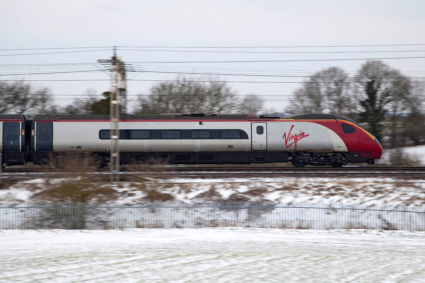 390115, VT 12.28 London Euston-Glasgow (1S16, 18L), between Roade & Ashton 
 390115 'Virgin Crusader' passes between Roade and Ashton in south Northamptonshire working the 12.28 London Euston to Glasgow Central. I like taking pan shots utilising slow shutter speeds, such as 1/200th sec. as used here. They don't always work but I think that this one has been a success. 
 Keywords: 390115 1S16 between Roade & Ashton