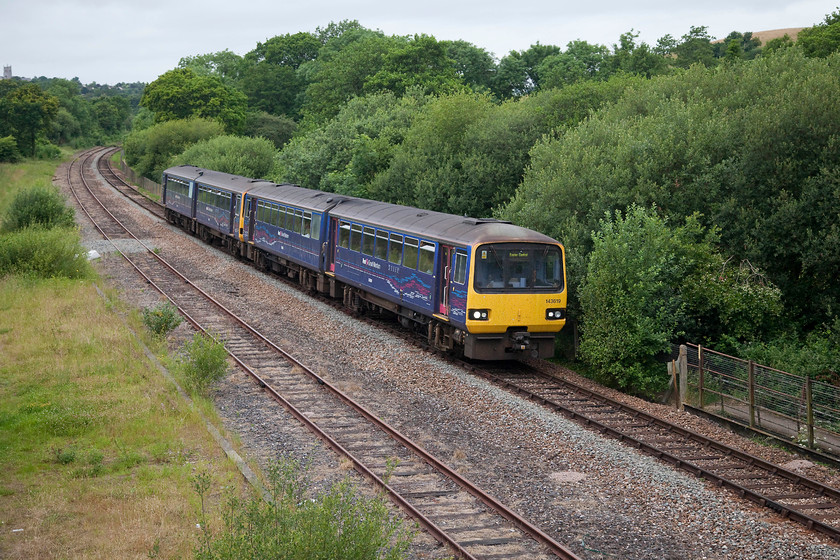 143319 & 143612, GW 07.00 Barnstaple-Exeter Central (2R89, RT), Yeoford 
 143319 and 143612 slow for their stop at Yeoford station working the 07.00 Barnstable to Exeter Central. Many of the passengers appeared to be lively school children! Whilst in this view it appears to a conventional double track arrangement it is in fact two different routes that run side by side. The unit is on the signal track Tarka Line that connects Barnstable with Exeter. The track to the left is in fact a long spur that separated from the other line at Crediton. It continues all the way to Meldon Quarries operated as a private line by the Dartmoor Railway that commences operations from Colebrooke. There are summer Sunday through workings operated from Exeter to Meldon. 
 Keywords: 143319143612 2R89 Yeoford